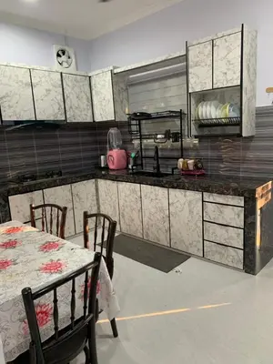 a kitchen with a table and chairs and a counter at Homestay D'Kutan Bandar Baharu Kedah in Bandar Baharu