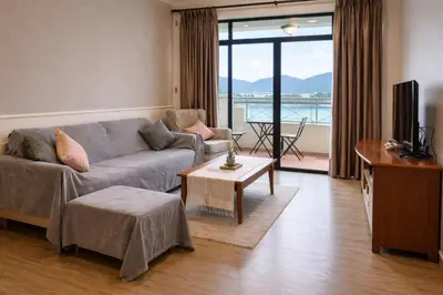 a living room with a couch and a television with a view at Azure Haven by the Sea-Lumut in Lumut