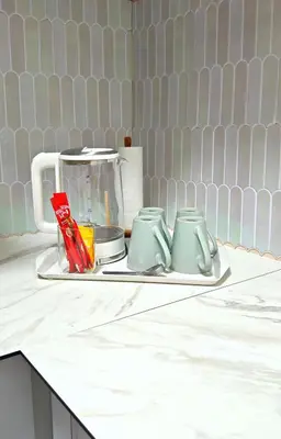 a counter with a tea pot and two mugs at Azure Haven by the Sea-Lumut in Lumut