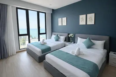 a bedroom with two beds and a large window at Luxury Sea view Sunset view Jazz Suites near Gurney in Tanjong Tokong