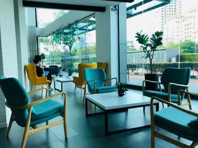 a person sitting in a room with chairs and tables at Luxury Sea view Sunset view Jazz Suites near Gurney in Tanjong Tokong