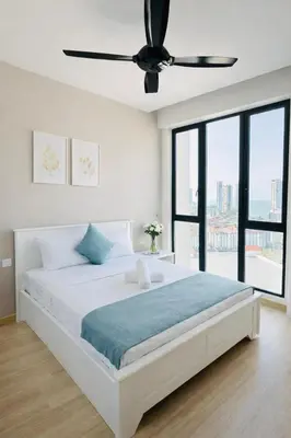 a white bedroom with a bed with a ceiling fan at Luxury Sea view Sunset view Jazz Suites near Gurney in Tanjong Tokong