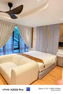a bedroom with a white bed and a couch at Adik Aisyah Hotel Studio Room Royal Silver centrum Brinchang in Brinchang