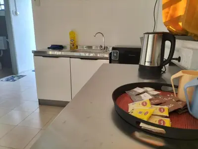 a kitchen counter with a tray of food on a table at Lahat Homestay in Lahat