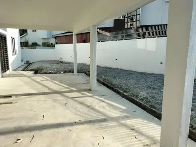 a white building with columns in the middle of a sidewalk at Lahat Homestay in Lahat