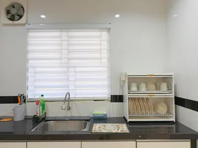 a kitchen counter with a sink and a window at Cozy Homestay 6-10pax Double storey in Bukit Mertajam