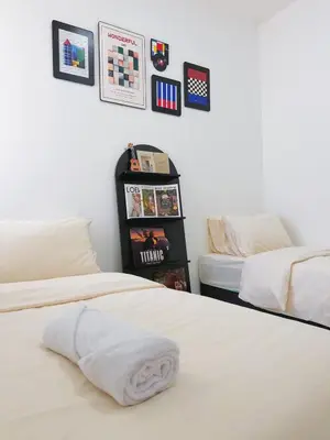 a bedroom with two beds with a towel on the bed at Cozy Homestay 6-10pax Double storey in Bukit Mertajam
