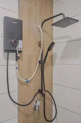a shower with a hose hooked up to a wall at Picaddily Suites by Homexa Hospitality in Ipoh