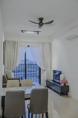 a living room with a table and chairs and a television at Picaddily Suites by Homexa Hospitality in Ipoh