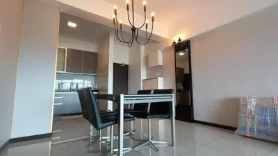 a dining room table with black chairs and a chandelier at Kinta Riverfront Apartment Riverview Apartment in Ipoh