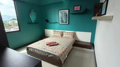 a bedroom with a bed in a blue wall at Kinta Riverfront Apartment Riverview Apartment in Ipoh