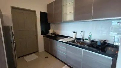 a kitchen with a counter with a sink and a door at Kinta Riverfront Apartment Riverview Apartment in Ipoh