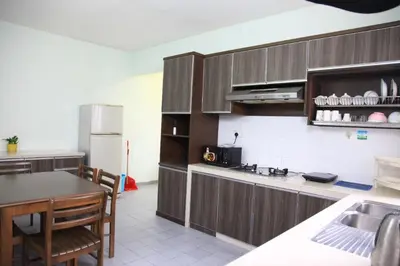 a kitchen with wooden cabinets and a table and a refrigerator at Isabella Villa George Town Penang in George Town