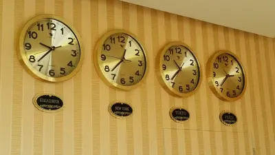 four clocks on a wall with different time zones at Amigo Hotel in Seri Iskandar