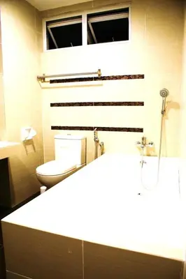 a bathroom with a toilet and a window in it at Shamrock Seaview 11 Villa in Batu Ferringhi