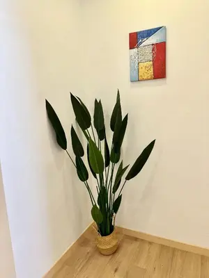 a plant in a vase in a room with a painting at Sakura 1 Homestay Kampar Landed in Kampar