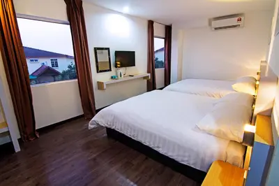 a hotel room with two beds and a window at Thanks Hotel in Parit Buntar