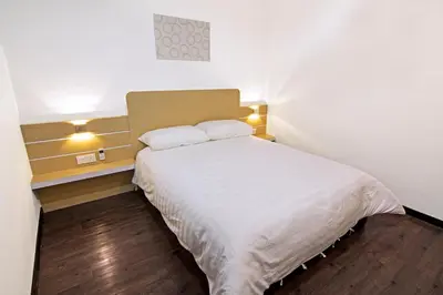 a small bedroom with a white bed with two pillows at Thanks Hotel in Parit Buntar
