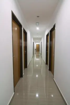 an empty corridor of a building with doors and a hallway at Thanks Hotel in Parit Buntar