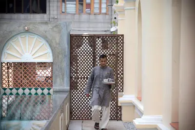 a man walking into a building with a box in his hand at Jawi Peranakan Mansion in George Town
