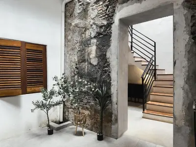a hallway with stairs and a stone wall at RARE Heritage House in George Town