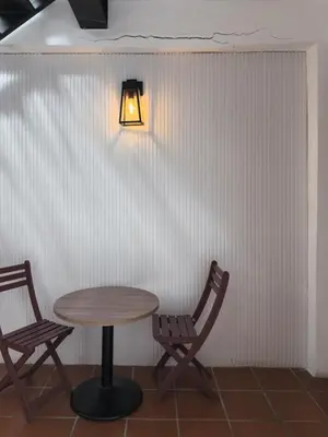 a table and two chairs and a light on a wall at RARE Heritage House in George Town