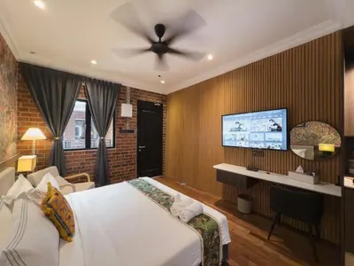 a bedroom with a bed and a ceiling fan at RARE Heritage House in George Town