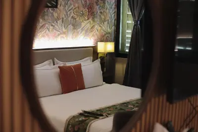 a bedroom with a bed with white sheets and orange pillows at RARE Heritage House in George Town