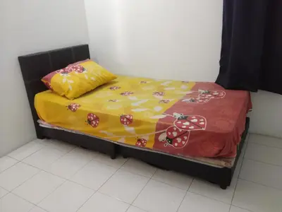 a small bed with a yellow and red blanket at The Simple Homestay in Simpang Pulai