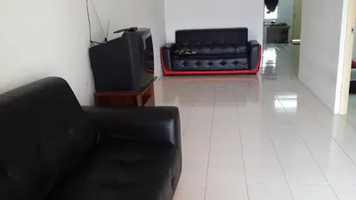 a living room with a black couch and a tv at The Simple Homestay in Simpang Pulai