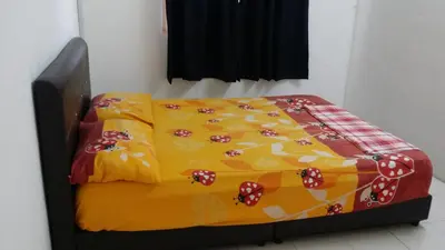 a bed with a colorful blanket on it in a room at The Simple Homestay in Simpang Pulai