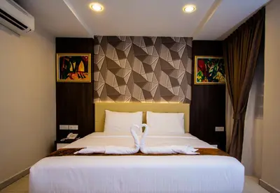 a bedroom with a bed with a towel on it at Louis Hotel in Taiping