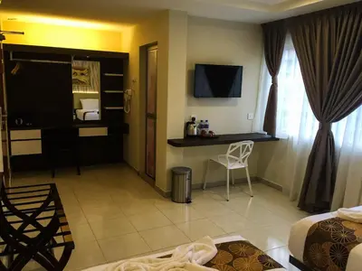 a hotel room with a bed and a desk in a room at Louis Hotel in Taiping