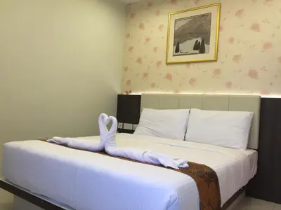 a hotel room with a bed with a towel on it at Louis Hotel in Taiping