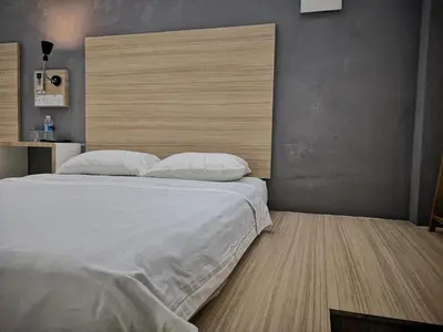a bedroom with a large bed with white sheets and pillows at Dragon Door Hotel in Sitiawan
