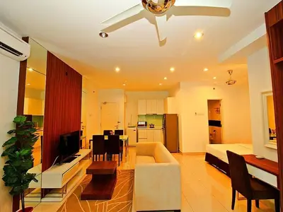 a living room with a couch and a dining room at Merlene Suites at Mansion One Formerly know as Mansion One Suites in George Town