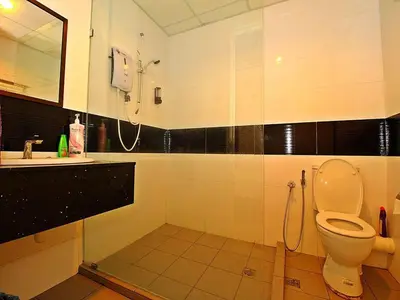 a bathroom with a toilet and a sink and a phone at Merlene Suites at Mansion One Formerly know as Mansion One Suites in George Town