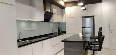 a kitchen with white cabinets and a black counter top at Merlene Suites at Mansion One Formerly know as Mansion One Suites in George Town