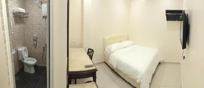 a small bathroom with a bed and a toilet at Sam Hotel Sitiawan in Sitiawan