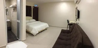 a hotel room with a bed and a bathroom at Sam Hotel Sitiawan in Sitiawan