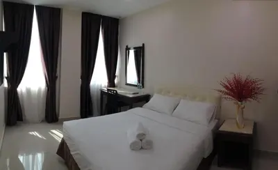 a bedroom with a bed with two white towels on it at Sam Hotel Sitiawan in Sitiawan