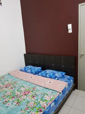 a bed with a floral quilt on top of it at Comfort On the Hill in Cameron Highlands