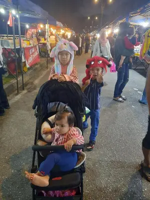 two children are sitting in a stroller at a market at Comfort On the Hill in Cameron Highlands