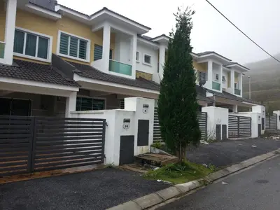 a house with a fence and a tree in the driveway at Comfort On the Hill in Cameron Highlands