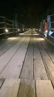 a long wooden bridge at night with street lights at Pangkor Home Sea Village in Pangkor