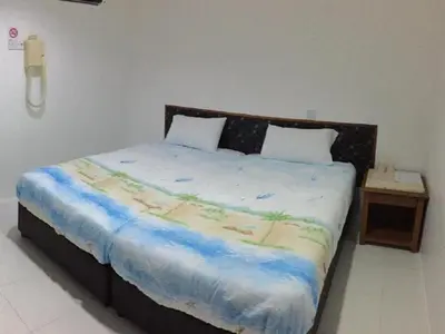 a bedroom with a large bed and a night stand at Pangkor Home Sea Village in Pangkor
