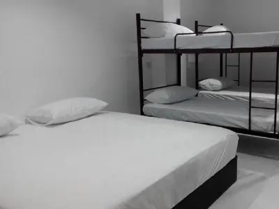 a bedroom with two bunk beds with white sheets at Pangkor Home Sea Village in Pangkor