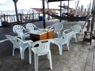 a group of white chairs and a table on a boat at Pangkor Home Sea Village in Pangkor