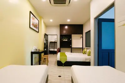 a hotel room with two beds and a blue door at Travelland Hotel in Ipoh