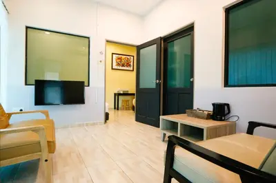a living room with a tv and a couch and a table at Travelland Hotel in Ipoh